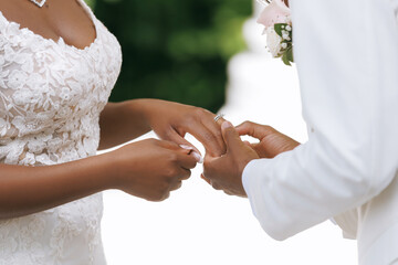 The groom puts a ring on the bride's finger during the wedding ceremony. Wedding of a beautiful...