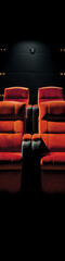 Obraz premium Two red plush cinema seats with cupholders in a dark auditorium