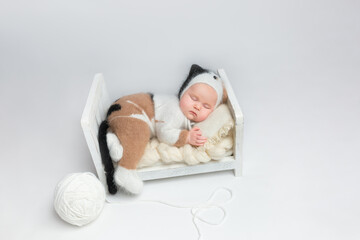 Little adorable newborn girl sleeps in a hat with cat ears. Neutral background. Studio shot of a ten-day-old newborn baby. Beginning of life. Fairy tale. kitten costume