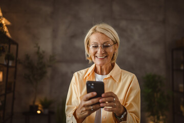 Portrait of mature senior woman sit and use mobile phone