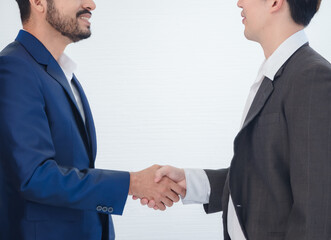 Business team man asian group stand on wall white look and shake hand with in agreement congratulation cooperate successful new plan project ready for happy work marketing sale in room office company