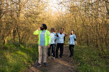 Fototapeta premium Civilian rescue squad beginning the manhunt mission in the forest, screaming the missing person name and tracking their steps. Rescuers party looking for clues and details, emergency.