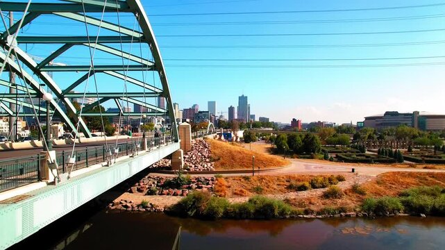 Aerial Shot Of Cars Moving On Bridge Road In Modern City Against Clear Sky, Drone Ascending Forward On Sunny Day - Denver, Colorado