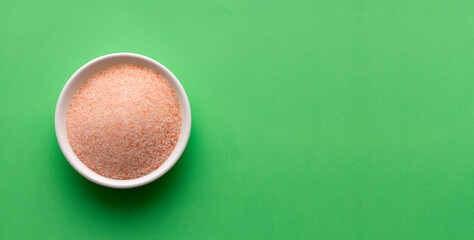 Fine Himalayan salt crystals in wooden bowl - Green background