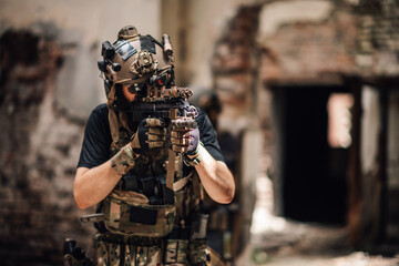 Portrait of brave soldier in uniform aiming with sniper rifle in ruins