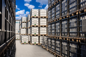 Street warehouse for liquid products. IBC containers in industrial area. Plastic square barrels on...