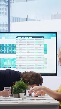Vertical video Employee choking in office, being helped by quick thinking coworker performing Heimlich maneuver. Worker offering first aid to colleague while coworker calls for ambulance, camera B