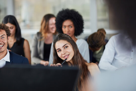 Thinking, woman and smile in seminar, listening and audience in event, training or presentation in boardroom. Workshop, idea and pen for notes of conference, entrepreneurship or masterclass in office
