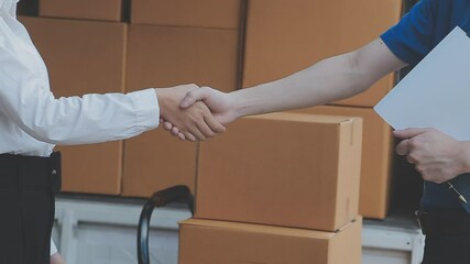 Young cheerful delivery man with parcel near car full of cardboard boxes, full length shot. Shipping service concept
