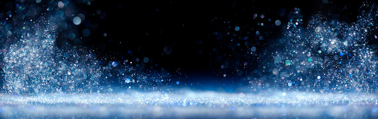 Sparkling blue and silver dust glittering and swirling around a center space with a dreamy or...