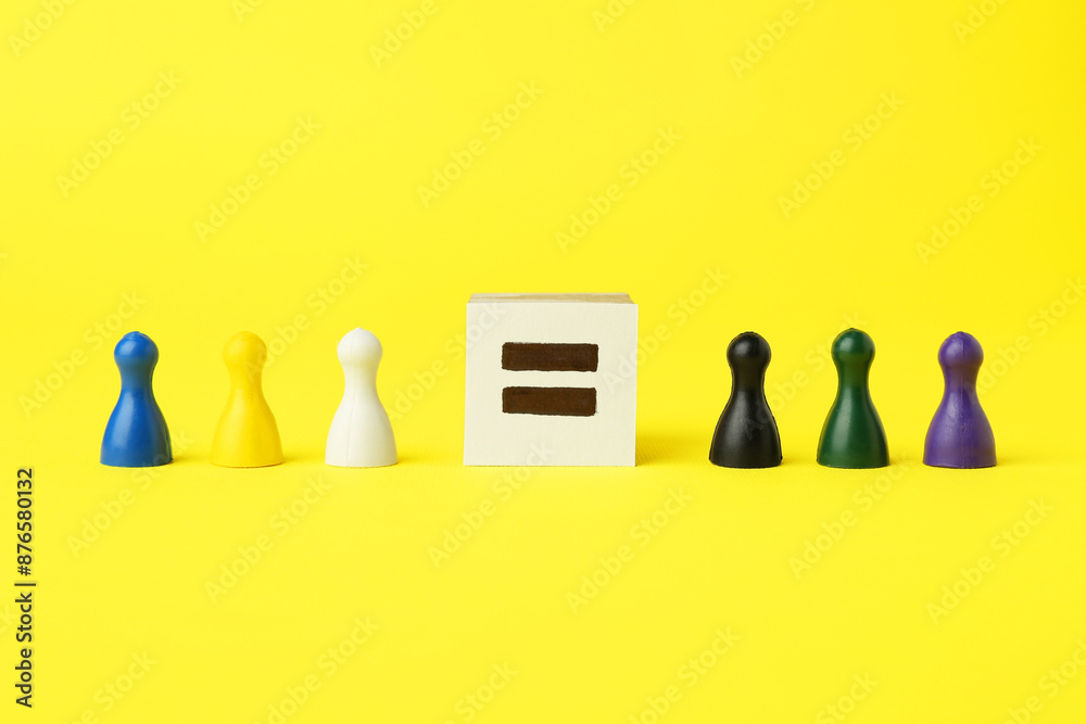 Wall mural Game pieces of different colors and equal sign on yellow background