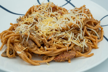 Philippine Sweet Spaghetti with Cheese on top and hotdogs.