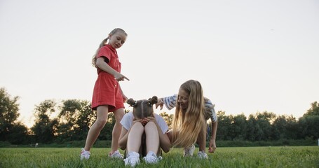 Obraz premium Upset Girl Crying as Peers Mock Her in Park - A Scene of Bullying Among Friends