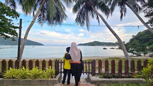 Imagr of Muslim mom and son at a beautiful beach