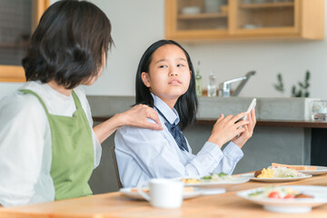 食事中にスマホを使う反抗期の子供と困る両親・家族
