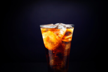 Close-up of soft drinks A glass of delicious refreshing summer water with ice cubes, isolated on black background. Closeup
