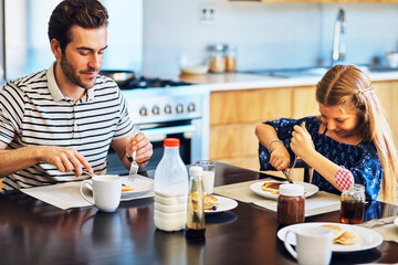 Dad, daughter and breakfast in kitchen, morning and eating in house, hungry and smile for pancakes. Home, girl and father in dining room, healthy and food on table, nutrition and ready for school