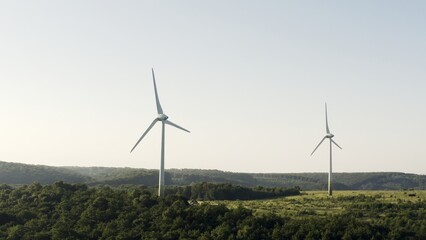 Serene Landscape with Wind Turbines Standing Tall Amongst Forested Hills