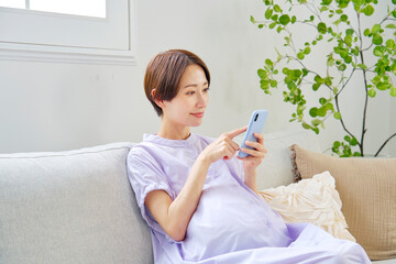 自宅でスマートフォンを使う高廉妊娠をした妊婦