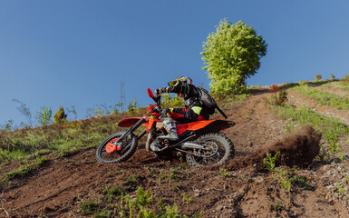 Professional enduro bike rider dirt ride on the muddy track. Motocross sport. 