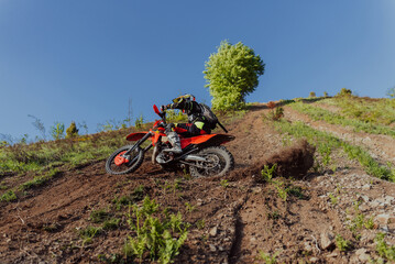 Professional enduro bike rider dirt ride on the muddy track. Motocross sport. 