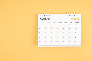 August 2024 desk calendar on yellow color background, position with copy space.