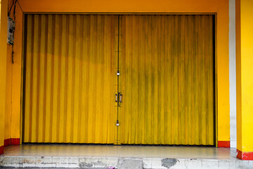 The closed shophouse gate uses a sliding iron door.