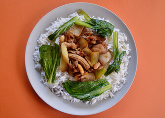 Chicken vegetables and rice an a plate.