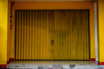 The closed shophouse gate uses a sliding iron door.
