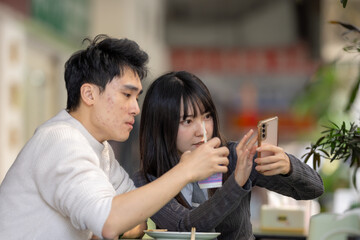 March, near the Zhongshan Memorial Hall in Zhongzheng District, Taipei City, Taiwan, Taiwanese woman in her twenties and a Hong Kong man are enjoying a meal of soy milk and radish cake at local shop.