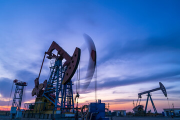 in the evening, oil pumps are running, The oil pump and the beautiful sunset reflected in the...