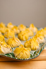 Homemade dumplings on a green leaf-patterned plate.
