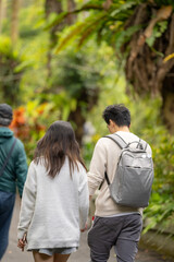 In March, a Taiwanese woman in her twenties and a Hong Kong man are walking in a lush botanical garden in Zhongzheng District, Taipei City, Taiwan.