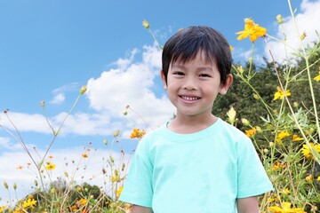 夏の青空を背景にした笑顔の可愛い日本人の男の子
