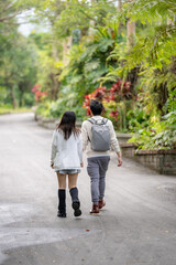 Obraz premium In March, a Taiwanese woman in her twenties and a Hong Kong man are walking in a lush botanical garden in Zhongzheng District, Taipei City, Taiwan.