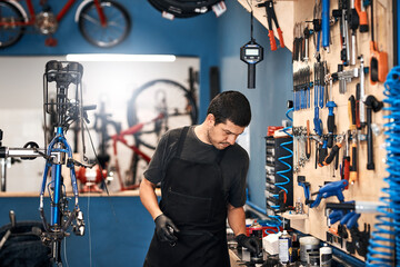 Bicycle repair, maintenance and tools with man in workshop for frame building or professional...