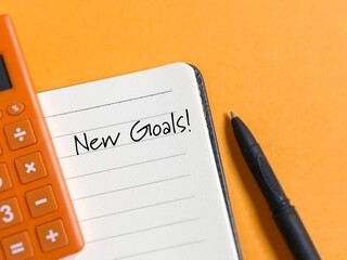 New goals text written on book with copy space background. Stock photo.