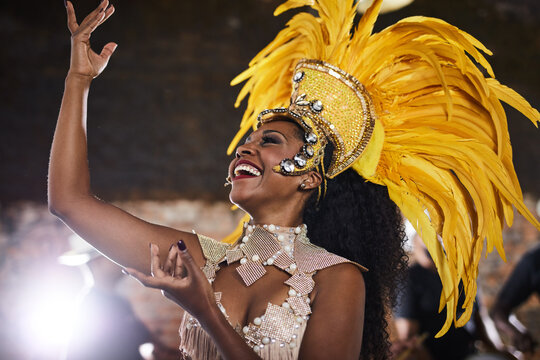 Woman, costume and carnival as samba dancer with music, parade and energy for celebration. Performance, happy and traditional outfit at night party with culture and crowd for event in rio de janeiro