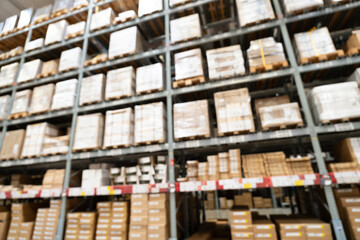 Abstract Blurred Storage Warehouse Logistics. Blurred industrial warehouse with goods and products. Logistics, business, delivery, services concept. Defocused industrial storehouse interior.