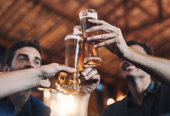 Beer, cheers and hands of friends in pub together for celebration, milestone or social gathering. Alcohol, glass and toast with group of people drinking beverage in bar for bachelor party or bonding