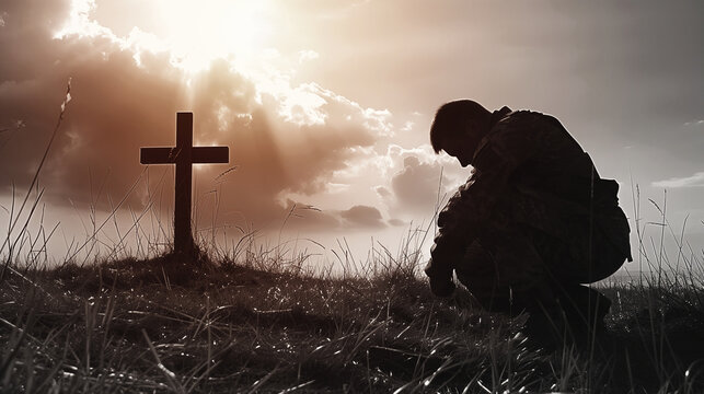 Black and white image of soldiers kneeling and bowing their heads in remembrance of those who sacrificed in the war on memorial Day.