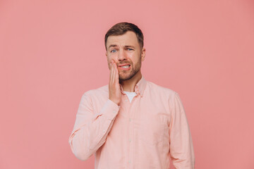 Handsome bearded man with hair wearing casual shirt touching mouth with hand with painful...