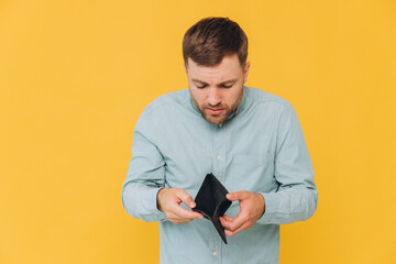 I'm Broke. Portrait of sad unshaven male bankrupt showing his empty wallet looking at camera. Upset...