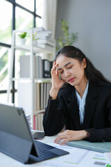 Asian businesswomen, tired, stressed office workers, headaches over delayed work hours. The work was not completed according to the supervisor's goals. Assigned executives Office syndrome concept.