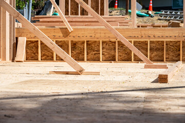 Wood framing started on new home construction job site, exterior walls with windows and subfloor
