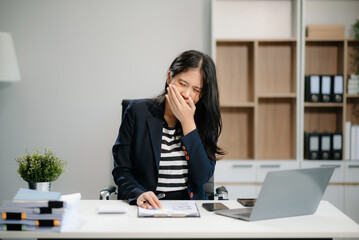 Asian business woman is stressed, bored, and overthinking from working on a tablet