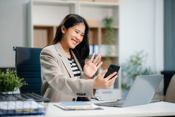  Beautiful Asian businesswoman typing laptop and tablet Placed at the table at the office