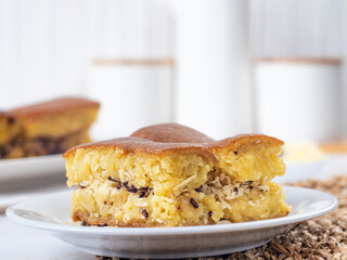 Close-up of a plate with Martabak Manis, an Indonesian sweet pancake filled with cheese and chocolate. Another plate with Martabak is visible in the blurred background.