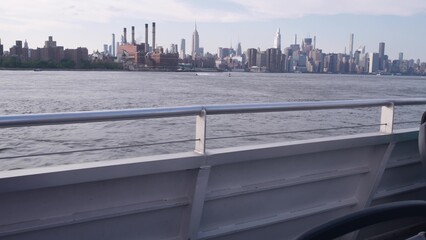 New York City skyline from ferry boat. Manhattan midtown highrise skyscrapers from ferryboat. East river waterfront panorama, riverfront architecture near water, USA. Empire State, Chrysler Building.