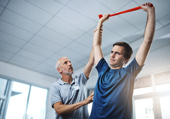 Resistance band for muscle or strength training and man with physiotherapist in office for checkup. Exercise, fitness or stretching and health professional with physiotherapy patient in rehab clinic